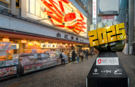 osaka, dotonbori - dec 6 2024: Expo 2025 Genkotsu sculpture designed by Japanese artist Hideyuki Matsuda aka Grand Cobra aside Kani Doraku, iconic crab restaurant, blending public art and urban energy