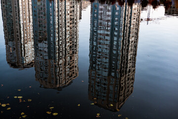 Abstract reflection of skyscrapers in calm blue water creating a unique visual. The mirrored...