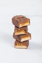 Chocolate Candy bar with nougat and caramel, peanuts and hazelnuts. Close up