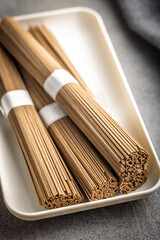Buckwheat soba noodles on plate on kitchen table.