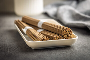Buckwheat soba noodles on plate on kitchen table.