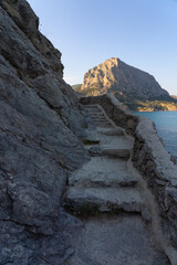 Stone stairs of the Golitsyn Trail in Crimea with a view of Mount Sokol and the sea