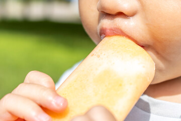 アイスを食べている男の子の口元（日本人、2歳、屋外）