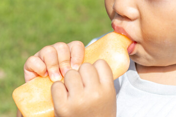 アイスを食べている男の子の口元（日本人、2歳、屋外）