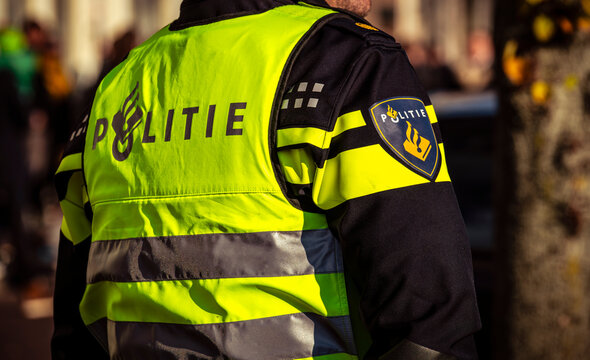 Dordrecht, Netherlands &ndash; November 17, 2018. A Dutch police officer seen from behind in uniform with a visible logo, symbolising law enforcement, authority, and public safety in the Netherlands