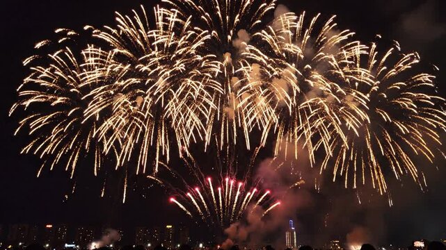 Colorful exploding fireworks display with sparks and smoke against black night sky