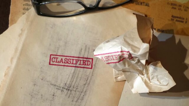 An old  sensitive documents and secret information with the stamp CLASSIFIED dolly shot