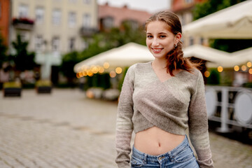 Young Woman In Old Town Center Happily Smiles