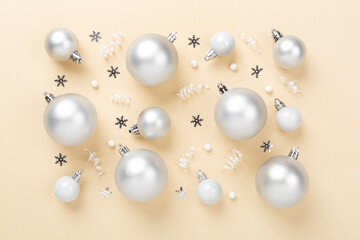 Grey Christmas balls with decor on color background, top view
