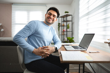 Portrait of smiling man at desk and laptop