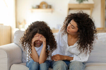 Caring worried mother comforting her crying daughter, mom supporting and soothing child girl...