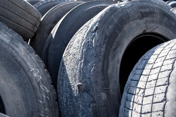 Pile of used car tires ready for recycling. Stacked old tires in a recycling yard. Old worn-out...