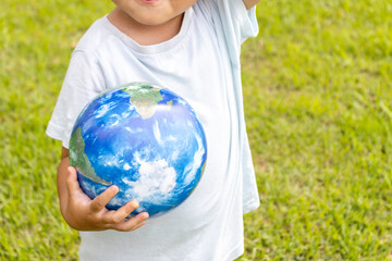 地球儀を持って草原で立っている男の子（2歳、日本人、顔無し）