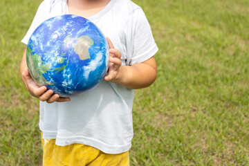 地球儀を持って草原で立っている男の子（2歳、日本人、顔無し）