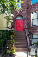 Colonial Style Residence With Red Door and Leaf-Covered Entry Path