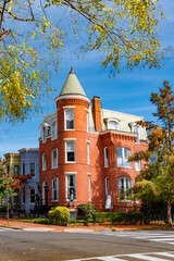 Classic urban townhouse with Victorian turret and lush landscaping © kosoff