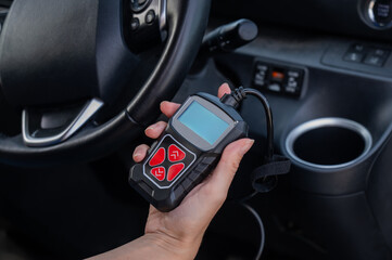 Woman using OBD2 diagnostic scanner. 