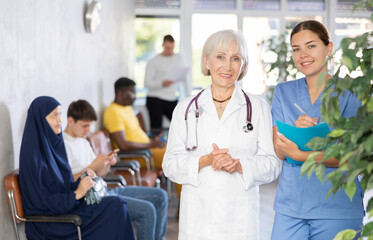 Obraz premium Portrait of an experienced female doctor and a young nurse in a medical clinic