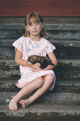 Nice young lady posing on stairs with her lovely ferret friend