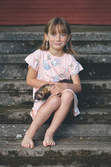 Nice young lady posing on stairs with her lovely ferret friend