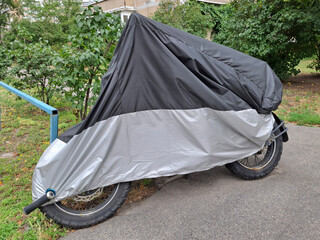 Black and gray cover on a motorcycle parked in the yard of a house © Harmony Video Pro