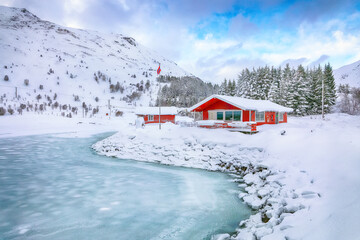 Amazing winter scenery with traditional Norwegian red wooden houses on the shore of Rolvsfjord.