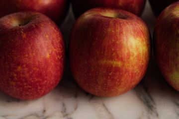 Fuji apples in rows on white marble table