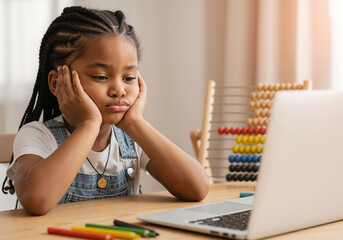 Bored Black girl tired of studying with laptop at home.