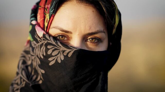 Beautiful veiled woman with green eyes looking intensely