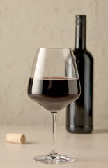closeup of red wine glass and bottle