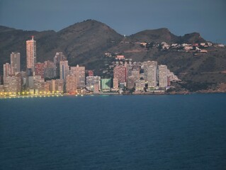 Fototapeta premium twilight seaside cityscape illuminated beautifully, sea view captures glowing urban horizon at dusk