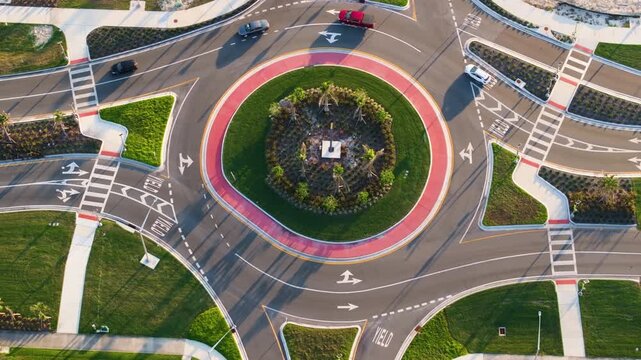 Traffic infrastructure in USA. Road roundabout intersection with driving cars. Circular transportation crossroads in Florida.