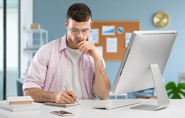 Naklejka premium Smart businessman thinking with computer in office
