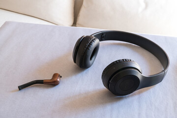 Wireless headphones and a mint smoking pipe on white paper