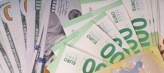 Various denominations of US Dollars and Euros are spread out on a flat surface