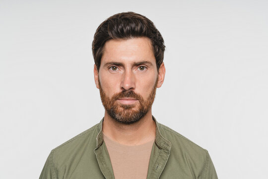 Young hoary man wearing casual green shirt standing isolated over white background. Relaxed with serious expression on face. Simple and natural looking at the camera. People and human expressions