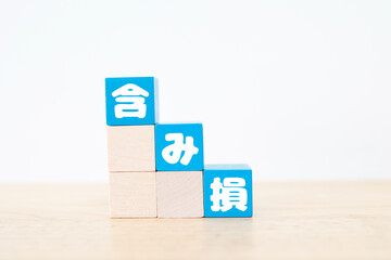 含み損の概念を表す青色ブロックと白背景のシンプルな金融イメージ。