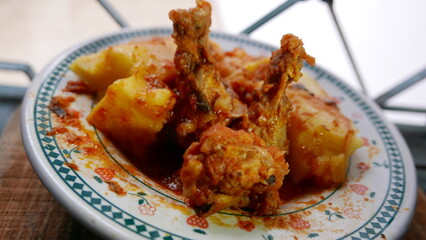 POV: Chicken thighs with polenta and sauce. Close-up of a plate of food by the window. Lunch time