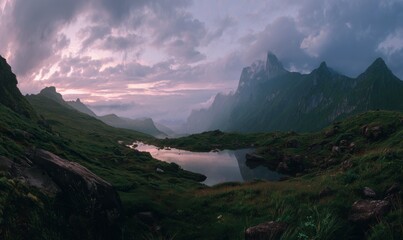 Dramatic mountain landscape with lake under a cloudy sky at sunset.