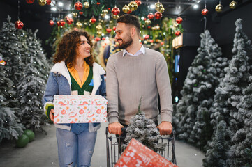 Couple shopping for christmas holiday decorations presenting a gift