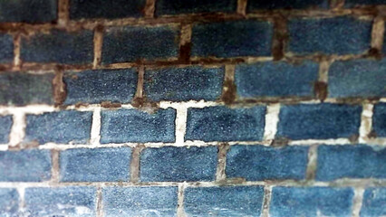 Close Up Textured View Of A Weathered Dark Blue Brick Wall With Visible Mortar Lines And Rough Surface Details