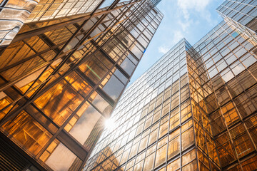 Looking up at the modern golden building facade from a low perspective

