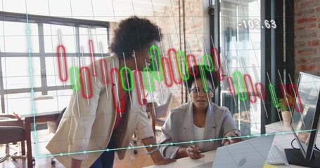 Working business women analyzing data on laptop, monitor in office, with candlestick overlay