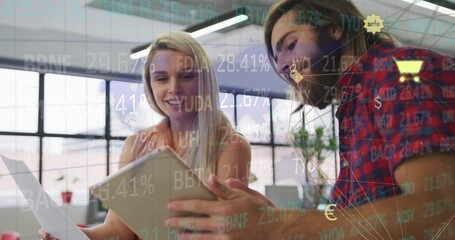 Reviewing coworkers examining report and tablet in modern open plan office, with data overlays