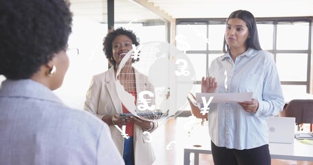 Business casual women reviewing finance data in office space, with tablet and digital globe