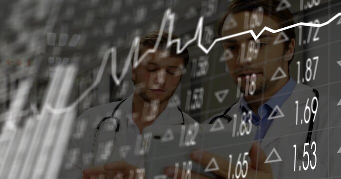 Reviewing tablet two doctors wearing lab coats, stethoscopes at hospital, with stock market overlay