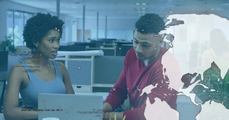 Colleagues wearing red sweater and blue top analyzing laptop in open office with digital overlays