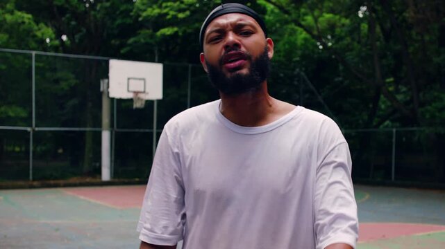 African American man wearing durag confronts camera with intense expression on outdoor basketball court, raw emotion and tension during street game moment
