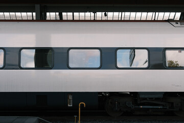 Stationary train at the railway station, view of carriages on the tracks