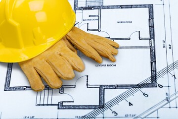 Hard hat and architectural drawings on the desk